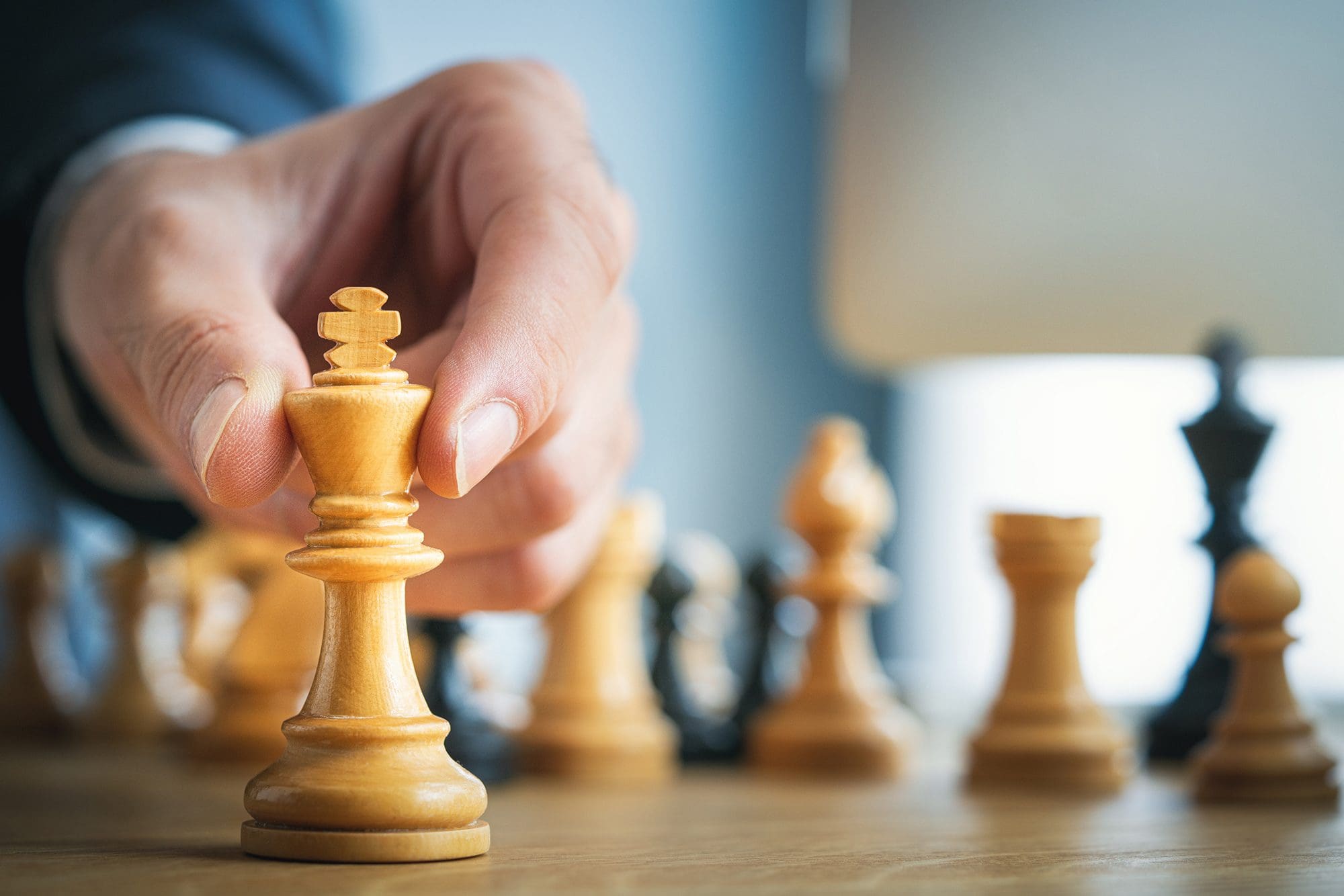 Business Strategy senior miving chess piece on a chess board