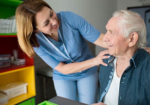 Happy caretaker assisting senior man