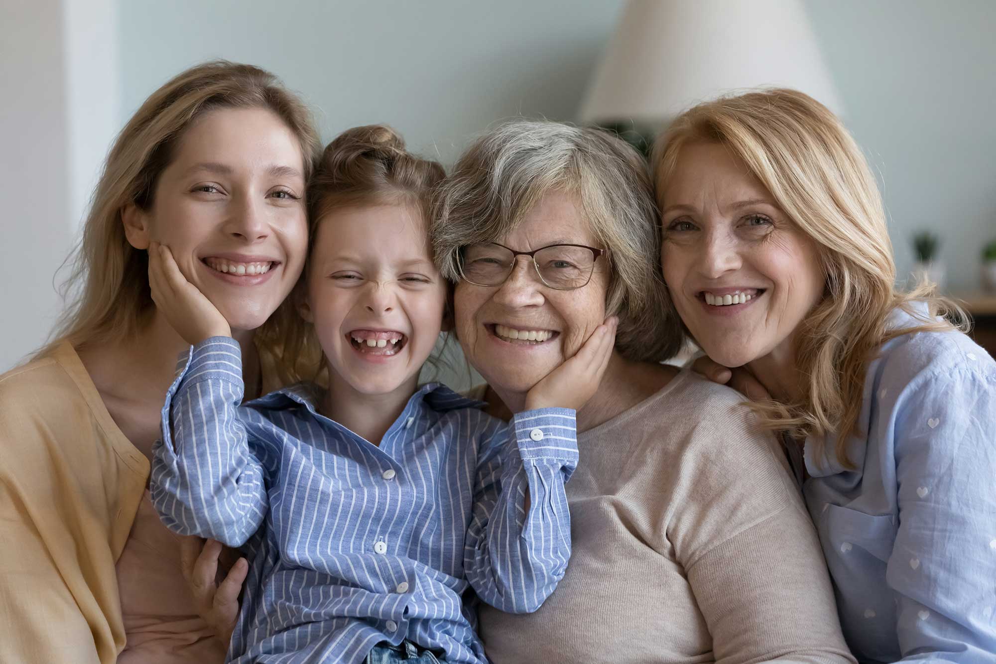 iStock-1475545170 Happy multi generational family portrait, next generation, heredity. Older and younger women posing looking at camera, having wide toothy smile advertise medical insurance, dental care clinic services