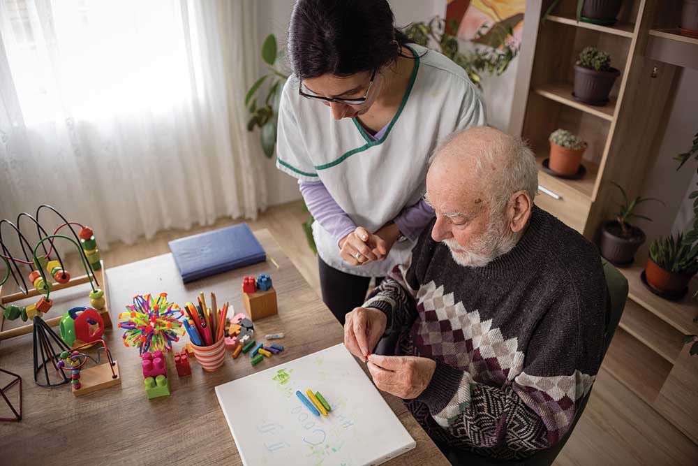 iStock-1487468206_1000px Bridges team and a Bridges resident holding up Purple Flag for Dementia Care