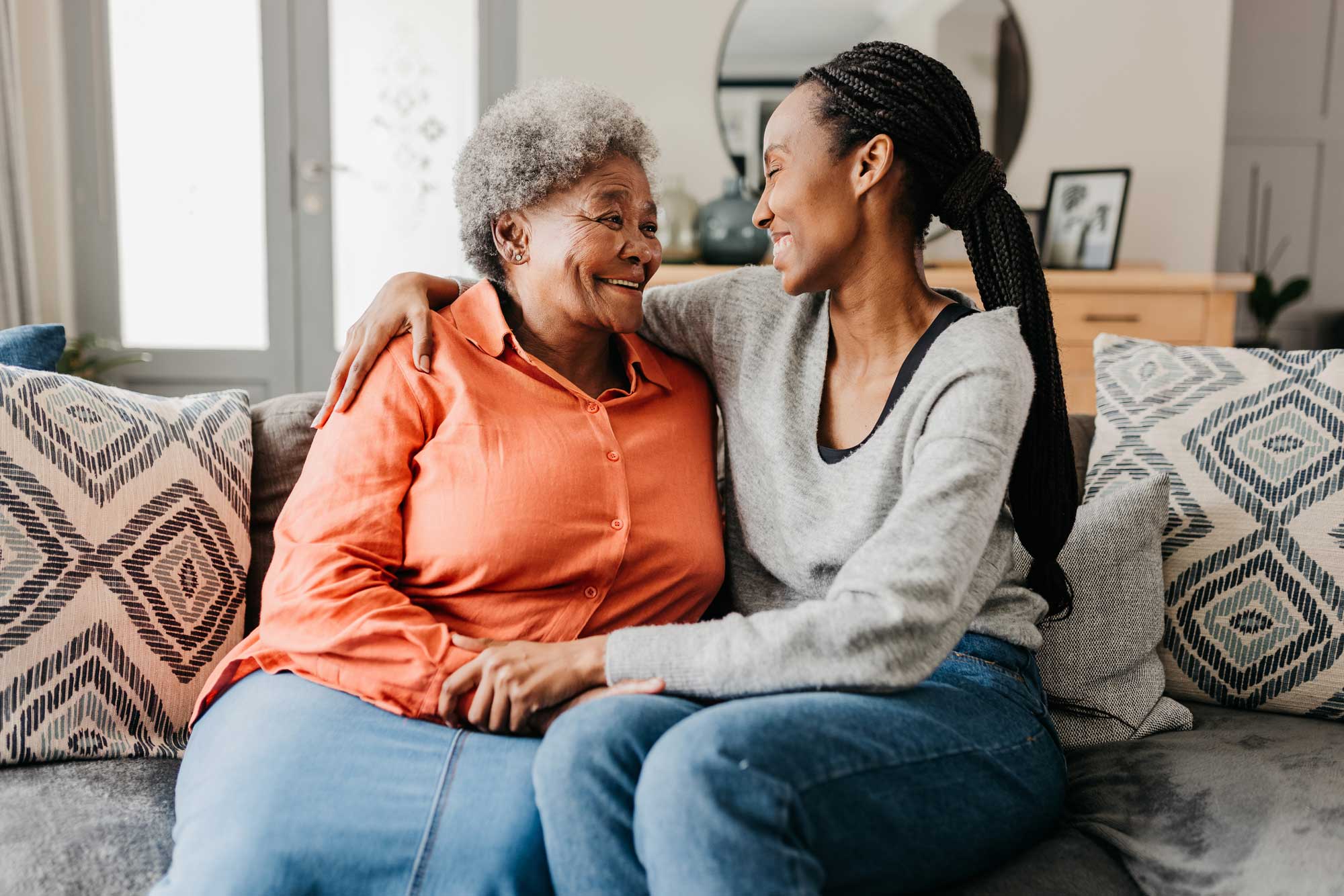 senior woman sitting on the couch with her adult daughter