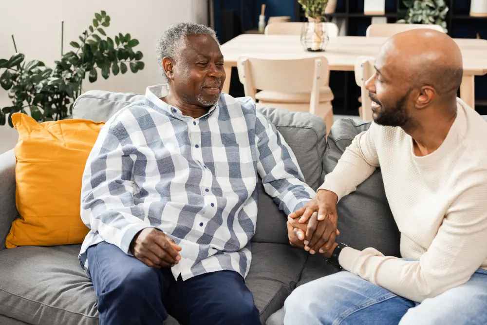 senior man sitting with his adult son in the living room